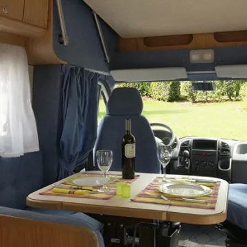 Dinette con sedute in tessuto blu coordinate con i sedili girevoli della cabina di guida.