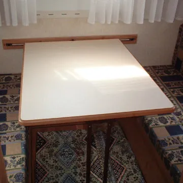 Zona dinette con divani in tessuto fantasia e tavolino abbassabile.