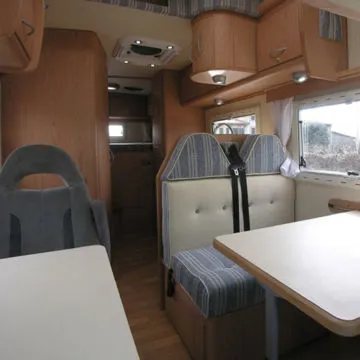 Zona dinette con tavolino raccordabile – sedute fronte guida con poggiatesta e cinture di sicurezza.