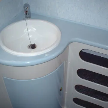 Bagno con base lavandino, laccato in colore bianco e azzurro, con portaoggetti a scomparti.