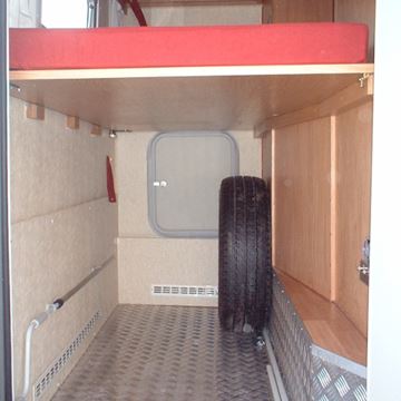 Il gavone posteriore del camper arredato con un letto singolo (aperto).